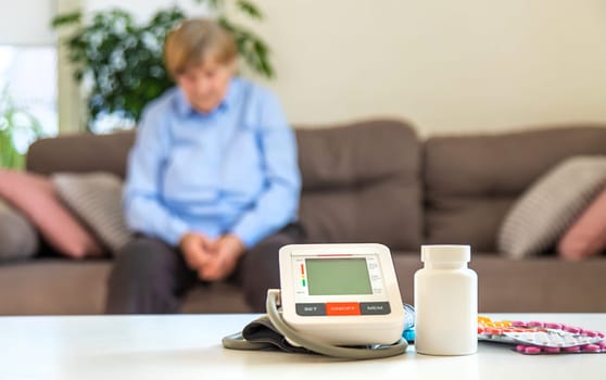 An old woman measures her blood pressure. Selective focus. people,