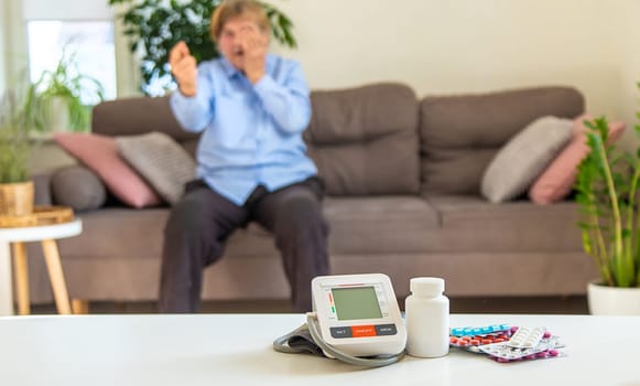 An old woman measures her blood pressure. Selective focus. people,