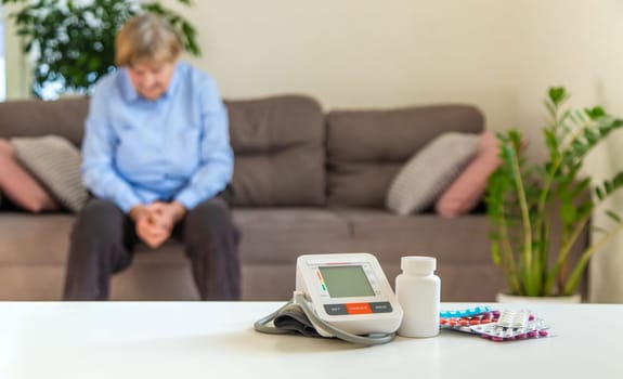 An old woman measures her blood pressure. Selective focus. people,