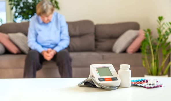An old woman measures her blood pressure. Selective focus. people,