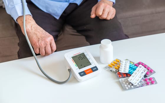 An old woman measures her blood pressure. Selective focus. people,