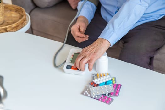 An old woman measures her blood pressure. Selective focus. people,