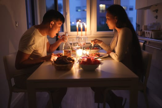 Young multi-ethnic couple having a romantic candlelit dinner in their apartment