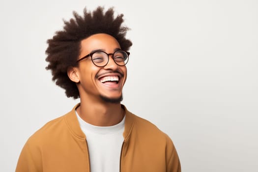 Portrait of happy modern young black American man with glasses smiles on white background, African male student looking away, studio shot
