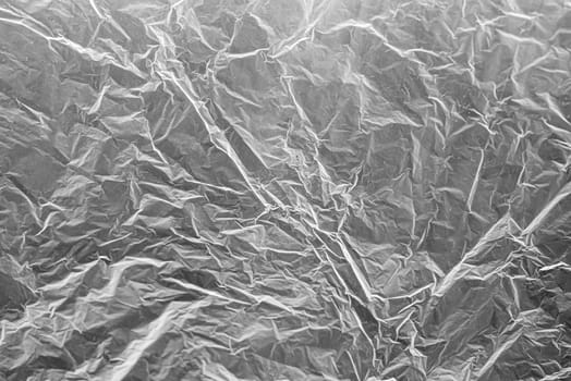 A textured light gray crumpled paper background with natural creases and folds. Ideal for design projects, digital graphics, or creative presentations requiring a vibrant.