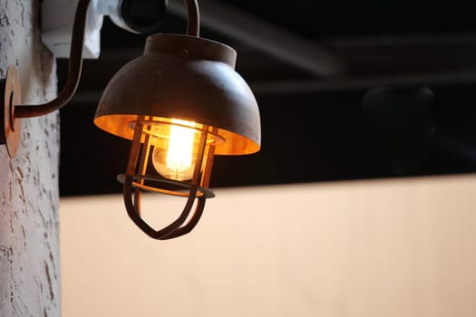 A warm metal lamp shines softly on a terrace, enhancing the ambiance.