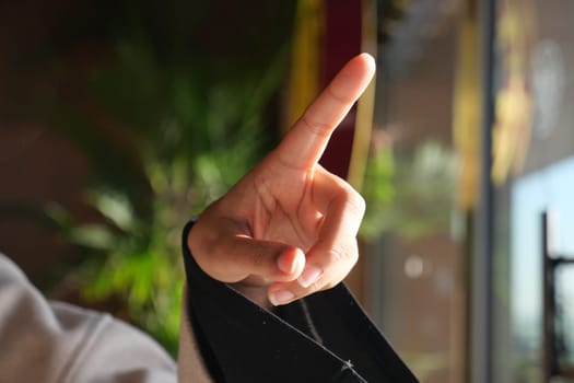 A hand is raised with one finger pointed, indicating a point of discussion.