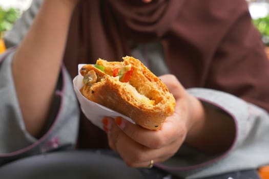 A person enjoys a freshly made savory snack filled with vegetables.