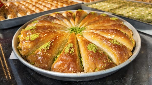 A tray of baklava filled with nuts and syrup sits in a bakery for sale.