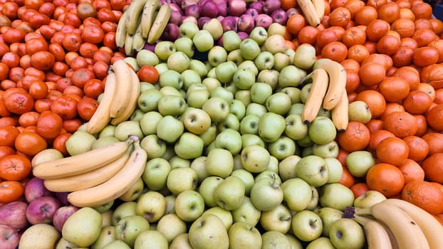 Fresh fruits like bananas, apples, oranges, and grapes are beautifully arranged.