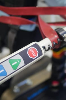 Close-up of a control panel on a mobility device with buttons and stop sign.