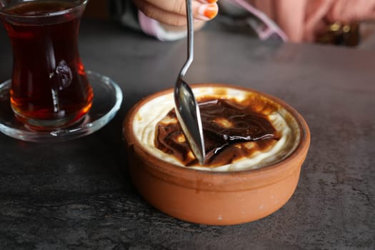 A dessert served with syrup and tea in a cozy setting.