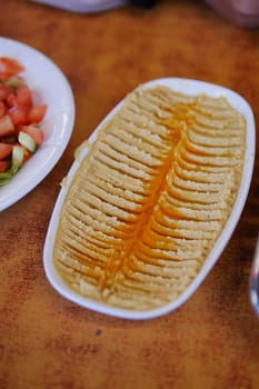 A creamy hummus plate garnished with a drizzle of oil and spices.