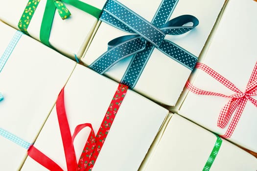 Stack of gift wrapped Christmas presents. Pile of presents is stacked neatly on the table. View from above.