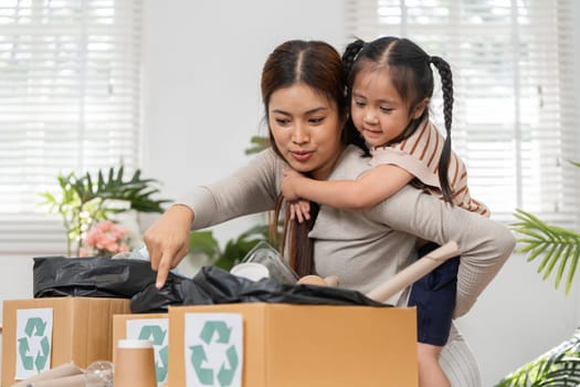 In their eco-conscious home, a mother shows her daughter the importance of recycling, fostering a love for nature and sustainability.