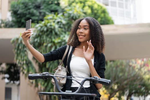 A young woman captures a cheerful moment while holding her bike, illustrating the enjoyment of outdoor adventures and commuting.