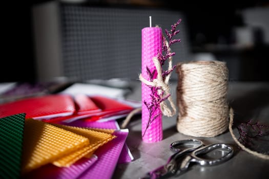 Colorful diy candle making with wax sheets and twine.