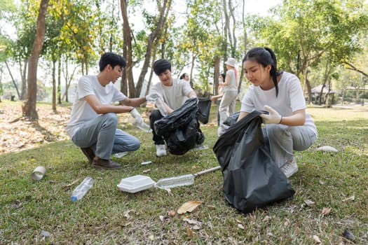 A group of volunteers collects various waste items in a park, emphasizing teamwork and environmental responsibility.