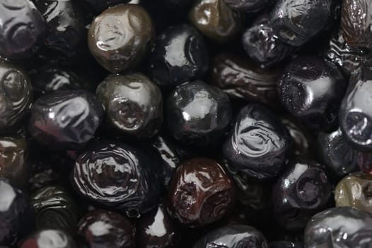Glossy black berries lay in abundance, showcasing their unique shapes and sheen, reflecting the beauty of fall harvest.