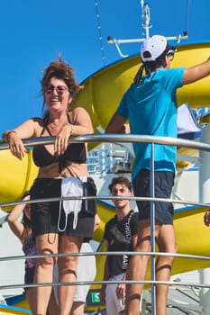 Catania. Italy - March 11, 2025: A male entertainer enthusiastically interacts with a smiling female guest on stage, showcasing vibrant energy and audience engagement.