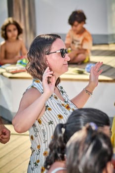 Catania. Italy - March 13, 2025: Woman with professional demeanor delivering an insightful talk to an interested crowd, highlighting expertise and engagement.
