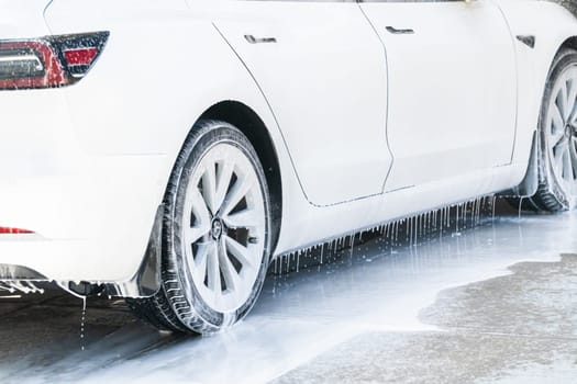 Denver, Colorado, USA-September 1, 2023-Efficiently cleaning an electric car in the comfort of a suburban driveway, combining eco-consciousness with practicality.