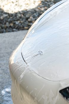 Denver, Colorado, USA-September 1, 2023-Efficiently cleaning an electric car in the comfort of a suburban driveway, combining eco-consciousness with practicality.