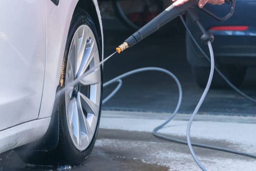 Denver, Colorado, USA-September 1, 2023-Efficiently cleaning an electric car in the comfort of a suburban driveway, combining eco-consciousness with practicality.