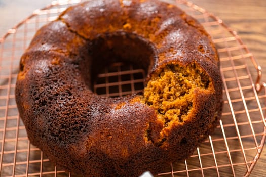 The gingerbread bundt cake cools gracefully on a wire rack, awaiting its sweet caramel frosting.