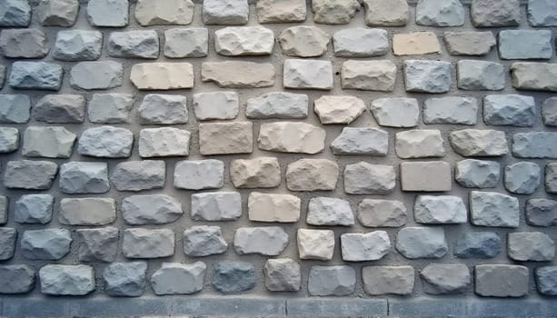 Smooth texture of a gray cobblestone wall or road backdrop. A path or pathway with a repeating surface pattern of tileable, gritty natural rock and stone. A 3D representation of a construction background in high resolution. . High quality photo