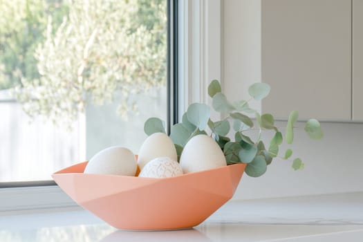 Simple colored Easter eggs arranged in a modern vessel with eucalyptus leaves make a stylish minimalist Easter centerpiece on a marble countertop, enhancing the spring ambiance.