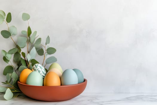 A stylish and minimalist Easter centerpiece showcases simple colored Easter eggs arranged in a bowl on a marble countertop, complemented by fresh eucalyptus leaves, perfect for seasonal decor.
