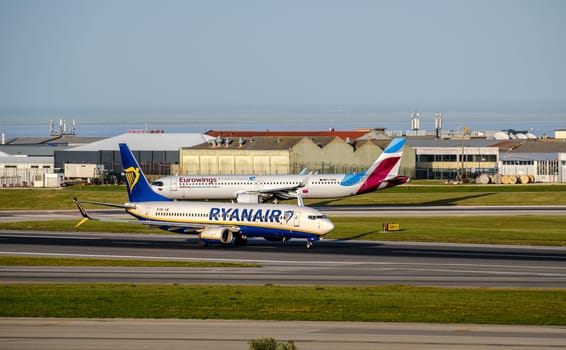 Lisbon, Portugal - Apr 3, 2024: Two commercial airplanes of Ryanair Boeing 737-800 and Eurowings Airbus A320 on Lisbon airport tarmac on sunny summer day, clear blue sky. Aircrafts taxiing, ready to depart, European travel hub, low-cost airlines