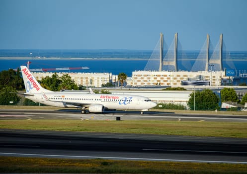 Lisbon, Portugal - Apr 3, 2024: Air Europa airline Boeing 737 aircraft taxiing on runway at Lisbon airport on sunny day, clear sky and bridge in background. Vacations, weekend getaway, summer travel destination, international hub, takeoff, landing