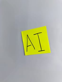 AI concept photography. AI inscription on sticky note. Handwritten word artificial intelligence for modern neural network project with simple design, vertical photo