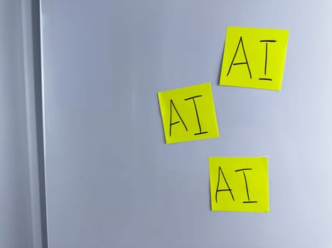 Note with the inscription AI. Colored stickers with the word artificial intelligence hang on white background for project about neural networks. Photo for simple background about modern technologies