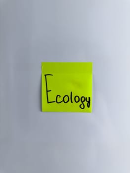 Vertical photo of sticky note with handwritten inscription Ecology. Concept of caring for nature and environment. Modern problems related to green energy and ecology of nature