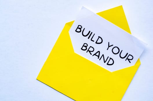 Build you brand text on a notepad inside an envelope. Branding concept.