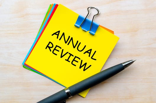 Top view of Annual Review text on yellow notepad.