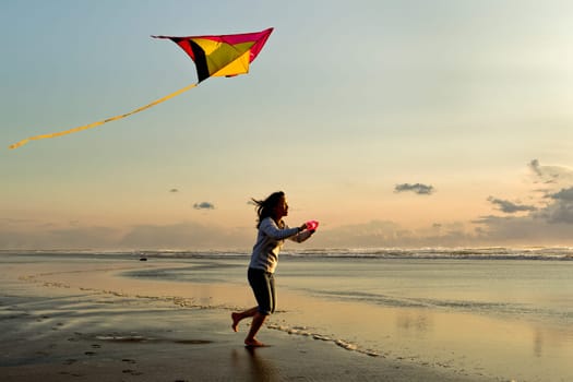 A woman flies a kite near sunset on the beach in Newport, Oregon.