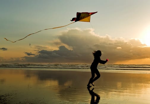 A girl flies a kite near sunset on the beach in Newport, Oregon.