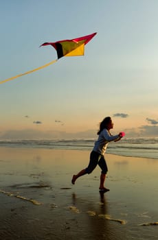 A woman flies a kite near sunset on the beach in Newport, Oregon.