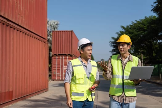 Two engineers engage in a strategic discussion about logistics while using a laptop, emphasizing modern planning techniques.