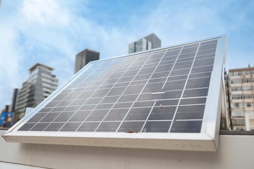 Solar panel absorbs sunlight on a city building rooftop.