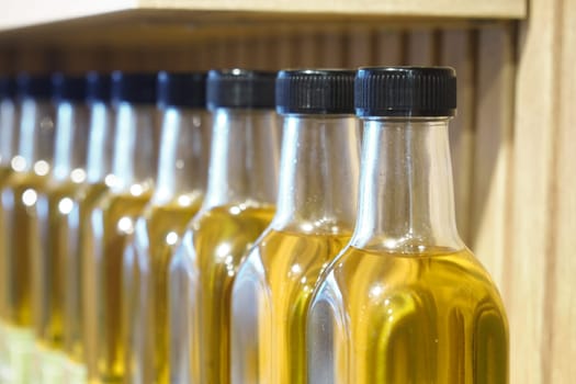 Row of glass bottles filled olive oil .