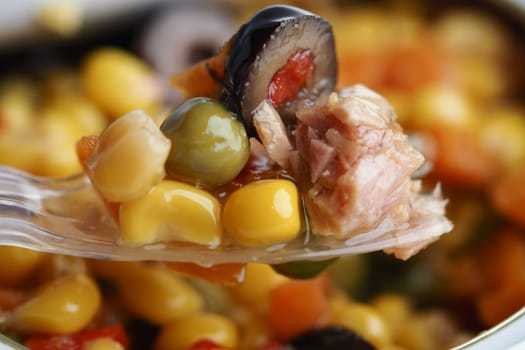 Colorful mix of vegetables and tuna served on a fork, ready to enjoy.