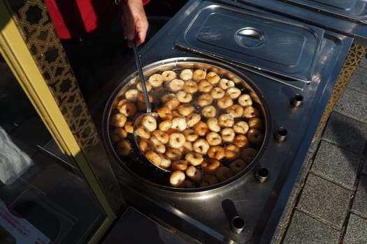 Freshly fried turkish lokma being prepared at a street food stall.
