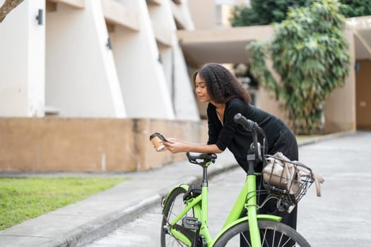 A young woman taking a moment to check her phone, embodies the eco-conscious commuter lifestyle while enjoying a break in her busy day.