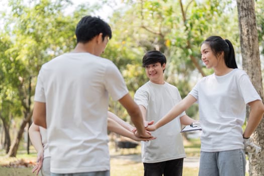 A group of engaged young volunteers collaborates in a park, preparing for their cleanup initiative while promoting teamwork and community spirit.