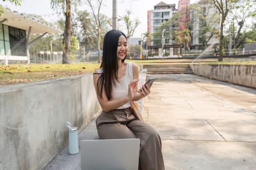 A joyful young woman engages with her smartphone, promoting a sustainable lifestyle in a beautiful outdoor environment.